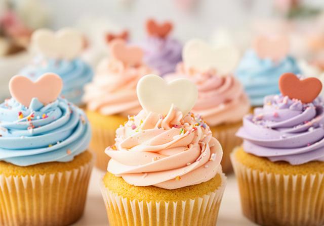 Cupcakes personalizados con crema de colores suaves y pequeños mensajes decorativos para una celebración